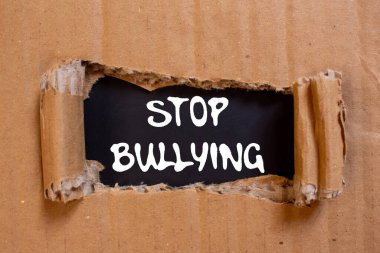 Siyah arka planda yırtık karton kağıda yazılmış mesajlara zorbalık etmeyi bırak. Kavramsal zorbalık sembolünü durdur. Boşluğu kopyala.