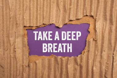 Mor arka planda yırtık bir karton kağıda yazılmış derin bir nefes mesajı alın. Kavramsal bir nefes alma sembolü. Boşluğu kopyala.