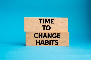 Mavi arkaplandaki tahta bloklara yazılmış alışkanlık mesajlarını değiştirme zamanı. Alışkanlık sembolünü değiştirmek için kavramsal zaman. Boşluğu kopyala.