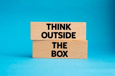 Mavi arka plandaki tahta bloklara yazılmış kutu mesajının dışını düşün. Kutu sembolünün dışındaki kavramsal düşünce. Boşluğu kopyala.