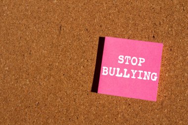 Kahverengi arka planda pembe kağıt etiketine yazılmış mesajlara zorbalık etmeyi bırak. Kavramsal zorbalık sembolünü durdur. Boşluğu kopyala.