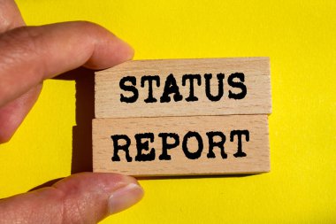 Sarı arka plandaki tahta bloklara yazılmış durum raporu mesajı. Kavramsal durum raporu sembolü. Boşluğu kopyala.