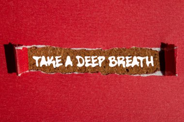 Kahverengi arka planda yırtık kırmızı kağıda yazılmış derin bir nefes mesajı alın. Kavramsal bir nefes alma sembolü. Boşluğu kopyala.