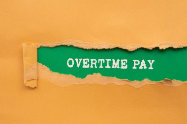 Fazla mesai ödemesi mesajı yeşil arka planda yırtık turuncu kağıda yazılmış. Kavramsal fazla mesai ödeme sembolü. Boşluğu kopyala.