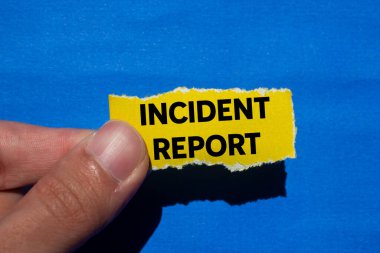 Olay raporu mavi arka planda yırtık sarı kağıt parçasına yazılmış. Kavramsal olay raporu sembolü. Boşluğu kopyala.