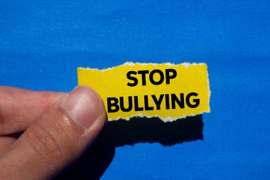 Mavi arka planda yırtık sarı kağıt parçasına yazılan mesajla uğraşmayı bırak. Kavramsal zorbalık sembolünü durdur. Boşluğu kopyala.