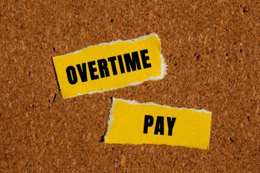 Kahverengi arka planda yırtık sarı kağıt parçalarına fazla mesai ödemesi mesajı yazılmış. Kavramsal fazla mesai ödeme sembolü. Boşluğu kopyala.