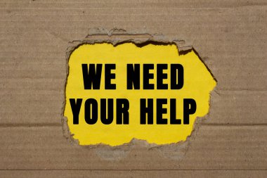 Sarı arka plandaki yırtık karton kağıda yazılı yardım mesajına ihtiyacımız var. Kavramsal olarak yardım sembolüne ihtiyacımız var. Boşluğu kopyala.