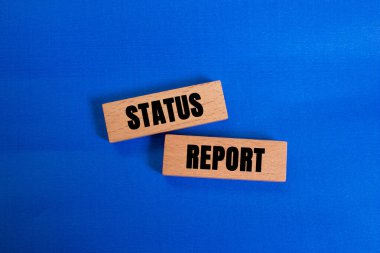 Mavi arkaplandaki tahta bloklara yazılmış durum raporu mesajı. Kavramsal durum raporu sembolü. Boşluğu kopyala.