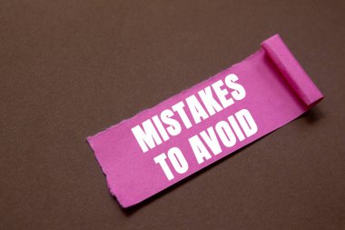 Kahverengi arka planda yırtık pembe kağıt parçasına yazılmış mesajlardan kaçınmak için yapılan hatalar. Sembolden kaçınmak için kavramsal hatalar. Boşluğu kopyala.