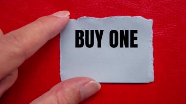 Buy One Get One message written on ripped torn paper background