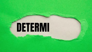 Determination message written on ripped torn paper background. Conceptual Determination symbol.