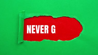 Never Give Up message written on ripped torn paper background