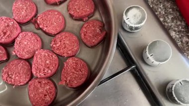 Raw slices of Turkish sucuk sausage cooking in sunflower oil pan