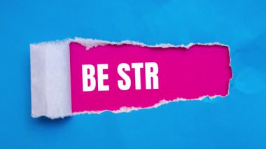 Be Strong message written on ripped torn paper background. Conceptual Be Strong symbol.