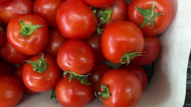 Fresh red tomatoes stacked together on display in grocery market