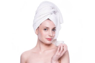 Temiz, yumuşak tenli, beyaz arka planda krem süren güzel, çekici, sarışın genç bir kadın. Güzellik bakımı yüz bakımı. Doğal stüdyo sağlıklı kozmetik portre. Kozmetik, güzellik, kaplıca.