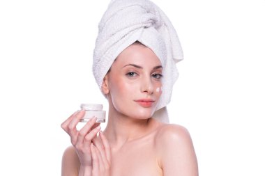 Temiz, yumuşak tenli, beyaz arka planda krem süren güzel, çekici, sarışın genç bir kadın. Güzellik bakımı yüz bakımı. Doğal stüdyo sağlıklı kozmetik portre. Kozmetik, güzellik, kaplıca.