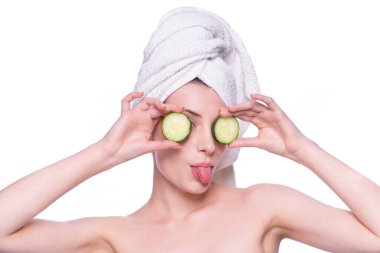 Temiz ve taze tenli güzel bir kadın, iki gözünün üstüne krem sürerek dil sürmesini sağlıyor. Gherkin bakımı. Doğal sağlıklı kozmetik komik portre. Kozmetik, güzellik, kaplıca