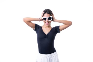 Komik beyaz güneş gözlüğü takmış, gülümseyen esmer bir kadının stüdyo portresi.