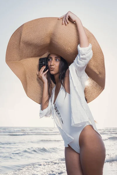 Фотосессия Красивой Молодой Женщины Позирующей Огромной Шляпе Винтажной Фотокамере Песке — стоковое фото