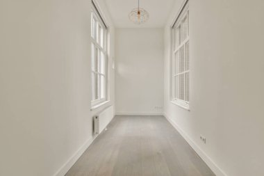 Evdeki boş ışık odasında, beyaz duvardaki plastik pencere ve radyatör.