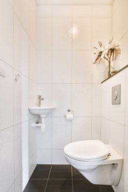 Lavabolu ve duvarlı, beyaz duvarlı ve kareli tuvaletli dar bir tuvalet.