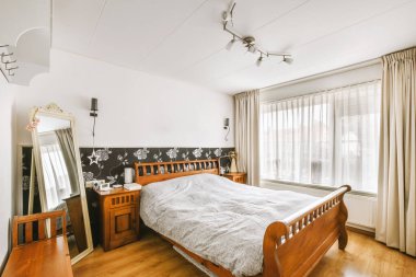 Yatak odasının iç tasarımı, yatak odası ve ahşap gardırop modern dairenin penceresinin kenarına yerleştirilmiş.