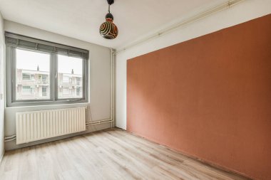 Evdeki boş ışık odasında, duvardaki plastik pencere ve radyatör.