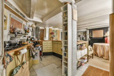 Dairenin geniş odasındaki dinlenme odası ve mutfağın yakınındaki sandalyeli ve çiçekli masa.