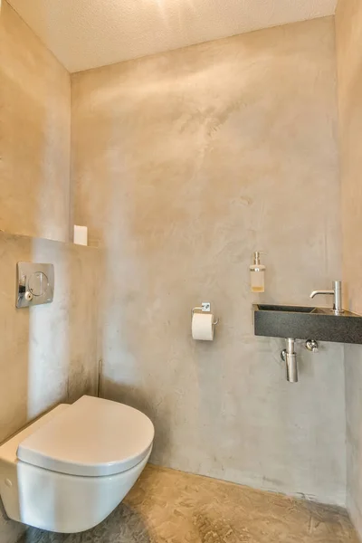 ボタンの下のベージュの壁に設置されたモダンなトイレと家の光のトイレの棚 — ストック写真