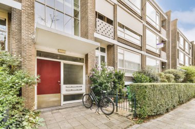 Ağaçlar ve fenerlerle dolu boş bir kaldırım sokağından tuğla evler manzarası