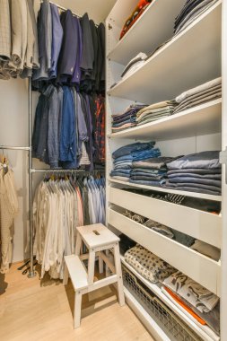 Modern dolap ve giysiler parke zemini olan ferah bir odada kapıların yanında.