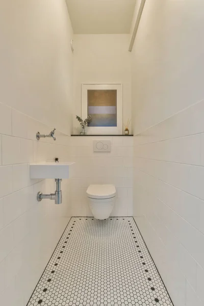 带有水池和墙壁的狭窄卫生间的内部悬挂着带有白色墙壁的厕所 — 图库照片