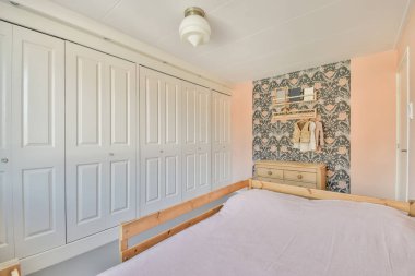 Comfortable bed with white bedclothes near window in light bedroom at home