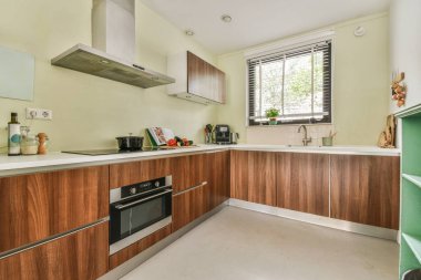 Çağdaş dairenin geniş odasındaki dinlenme odası ve mutfağın yakınındaki sandalyeli ve çiçekli masa.