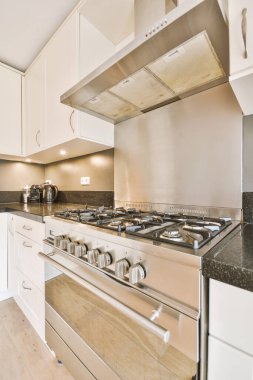 Çağdaş açık mutfak, yemek masası seti ve ferah odada gri kanepe.