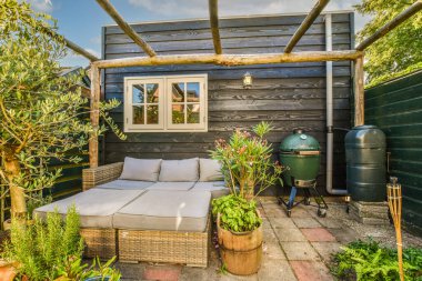 Neat powerful patio with sitting area and small garden near wooden fence