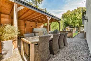 Neat powerful patio with sitting area and small garden near wooden fence