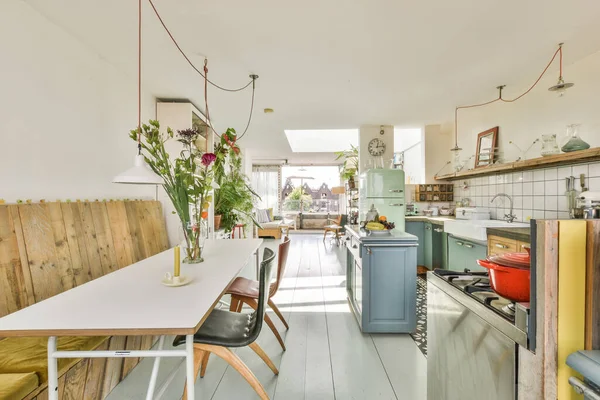 Stůl Židlemi Květinami Nachází Blízkosti Obývacího Pokoje Kuchyně Prostorné Místnosti — Stock fotografie
