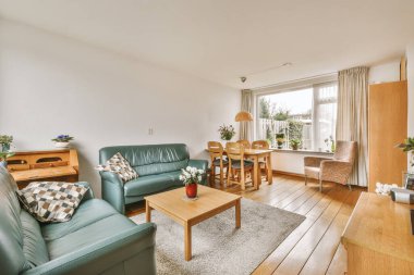 TV 'nin yanındaki koltuklar ve masa, çağdaş apartmandaki geniş odalı yemek alanına karşıdır.