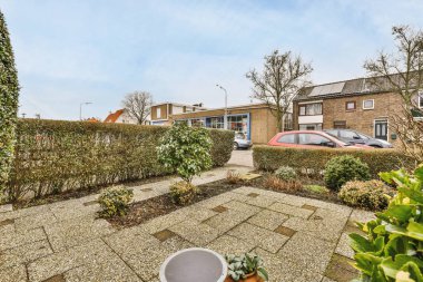 Arabaları, ağaçları ve fenerleri olan boş bir kaldırımdan panorama manzaralı evler.