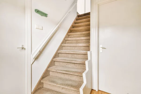 額装された写真の近くにある部屋の白いドアと自宅で階段の上にスタイリッシュなランプ — ストック写真