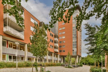 Arabaları, ağaçları ve fenerleri olan boş bir kaldırımdan panorama manzaralı evler.