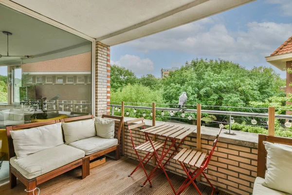 stock image Sitting area in balcony with comfortable furniture around beautiful view