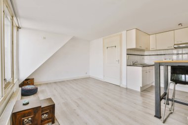 Gündüz vakti çağdaş dairede balkon kapıları olan hafif mutfak ve yemek odasının içi