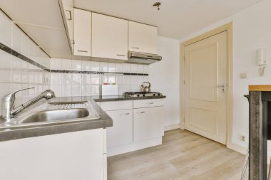 Gündüz vakti çağdaş dairede balkon kapıları olan hafif mutfak ve yemek odasının içi