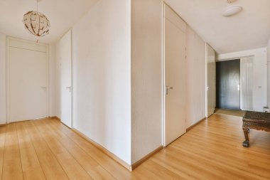 Günümüz minimalist tasarımı. Hafif stüdyo dairesinin ahşap masası ve oturma odası ile beyaz duvarları ve parke zemini arasında yemek masası ve sandalyeleri var.