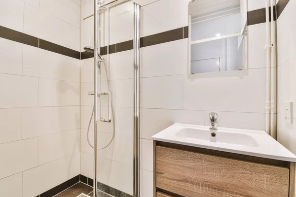 白いタイル張りの壁と光のトイレとシンクの近くにオープンシャワー付きのバスルーム — ストック写真