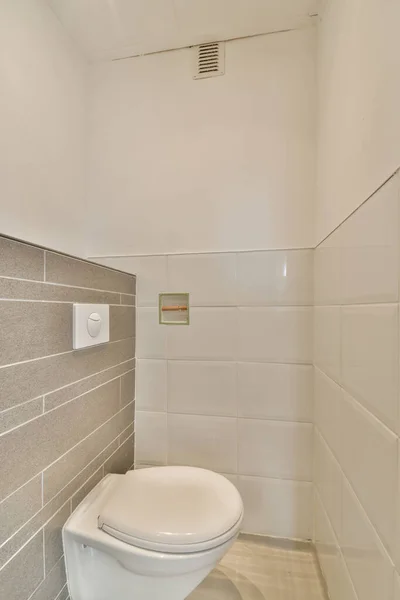 ベージュの壁に設置された現代的なトイレは 自宅のトイレのボタンの下に — ストック写真